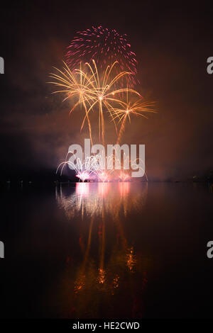 Colorato spettacolari fuochi d'artificio riflettendo in acqua Foto Stock