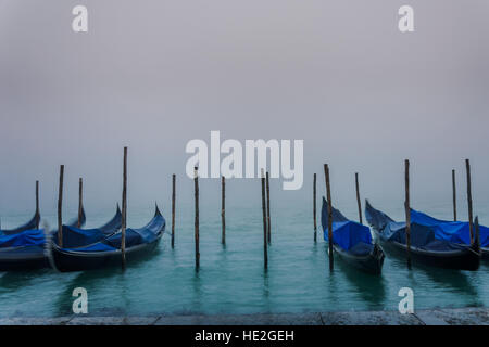 Gondole a Venezia presso la mattina presto sulla laguna coperta di nebbia Foto Stock