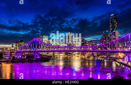 Vivace notte tempo panorama della città di Brisbane con luci viola sul Ponte Story, Australia Foto Stock