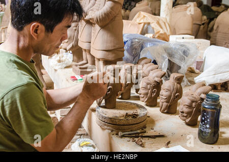 Operaio di Carver che produce guerrieri di terracotta e altri souvenir a Xian, Cina. Foto Stock