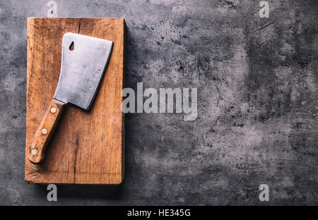 Butcher. Vintage macellaio cleavers di carne con un panno asciugamano sul cemento scuro o cucina in legno bordo. Foto Stock