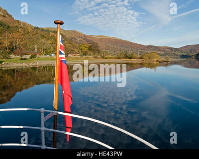 Riflessioni in Lake Ullswater visto su bianco stern rotaie del Western Belle 'steamer' Ullswater traghetto, Lake District, Inghilterra, Regno Unito. Foto Stock