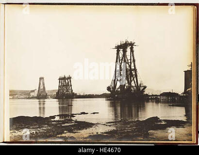 Questa fotografia storica mostra la costruzione del Forth Bridge, scattata a tarda serata. Questo iconico ponte è un'impresa ingegneristica e un importante punto di riferimento nella storia industriale della Scozia. Foto Stock