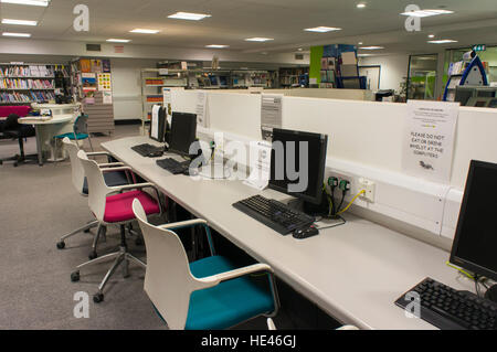 Interno di una libreria, West Yorkshire, Inghilterra - scrivania con computer e posti a sedere, anche gli scaffali con righe di libri. Foto Stock