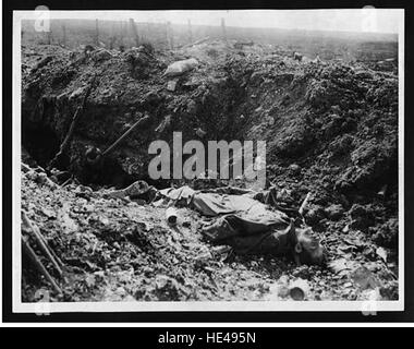 Questa fotografia storica mostra le conseguenze di una battaglia durante la prima guerra mondiale, con i corpi dei soldati tedeschi giacenti in una trincea catturata. L'immagine serve come un chiaro ricordo della devastazione e della brutale realtà della guerra. Foto Stock