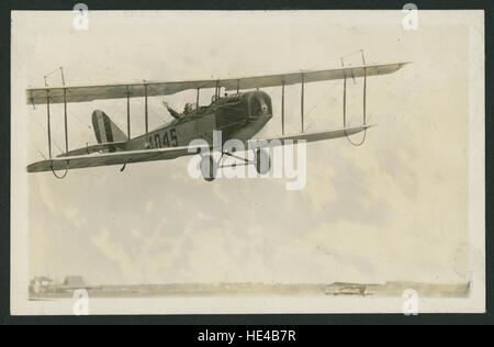 Il Curtiss JN-4D "Jenny", uno dei biplani più iconici dell'inizio del XX secolo, è mostrato in questa immagine con un aviatore che salta dalla cabina di pilotaggio. La "Jenny" fu fondamentale nell'aviazione militare e civile degli Stati Uniti durante e dopo la prima guerra mondiale Foto Stock