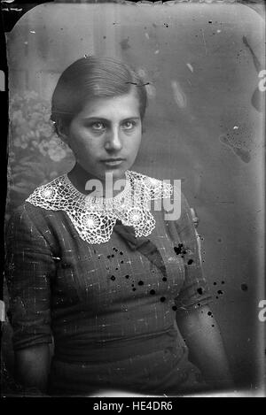 Un ritratto di una giovane donna dell'Archivio Costică Acsinte, catturato su una lastra di vetro negativa all'inizio del XX secolo in Romania. Questa fotografia storica offre un assaggio della cultura rumena, della vita rurale e della storia familiare. Foto Stock