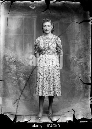 Un ritratto d'epoca di una donna rumena dell'inizio del XX secolo, catturato in abbigliamento tradizionale da Costica Acsinte. Questa lastra di vetro negativa riflette la cultura rurale della regione di Ialomita e il patrimonio rumeno. Foto Stock