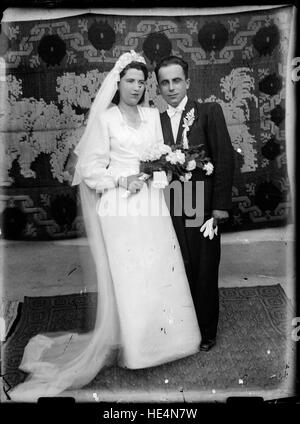 Un ritratto storico di una sposa e di uno sposo scattato nel 2015 in Romania, conservato su lastre di vetro dall'Archivio Costică Acsinte. Foto Stock