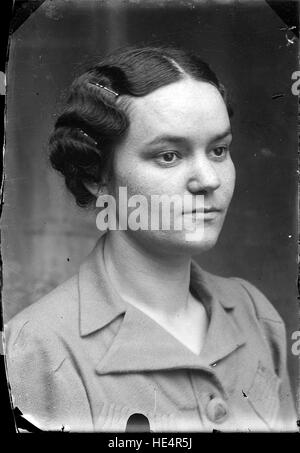 Un ritratto semi-profilo di una donna dell'Archivio Costica Acsinte, catturato all'inizio del XX secolo in Romania. La fotografia, scattata su una lastra di vetro negativa, riflette la cultura, la storia e la vita rurale rumena a Ialomita. Foto Stock