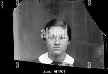 Un ritratto di una donna in uniforme dall'Archivio Costică Acsinte, catturato su una lastra di vetro negativa all'inizio del XX secolo in Romania. La fotografia storica mette in risalto il servizio militare rumeno durante l'epoca e offre informazioni sui costumi sociali e sulla storia familiare. Foto Stock