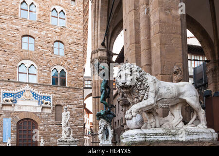 Firenze, Italia - 4 Novembre 2106: Medici Lion e Perseus statue nella Loggia dei Lanzi e Palazzo Vecchio di Piazza della Signoria in mattina. Il P Foto Stock