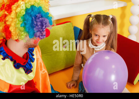 Divertenti clown dare aria palloncino per la bambina Foto Stock