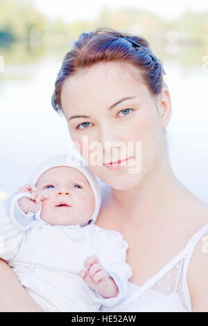 Giovane madre, 22 anni, con la figlia, sei settimane, all'aperto Foto Stock