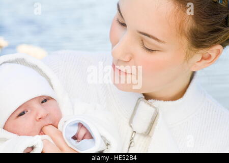 Giovane madre, 22 anni, con la figlia, sei settimane, all'aperto Foto Stock