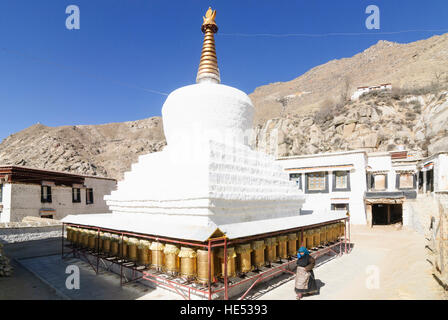 Lhasa: il Monastero di Sera; bianco Chörten tibetano, donna diventa preghiera Mills, Tibet, Cina Foto Stock