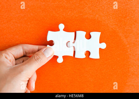 Donna raccordo di mano destra pezzo del puzzle suggerendo di business networking concept Foto Stock