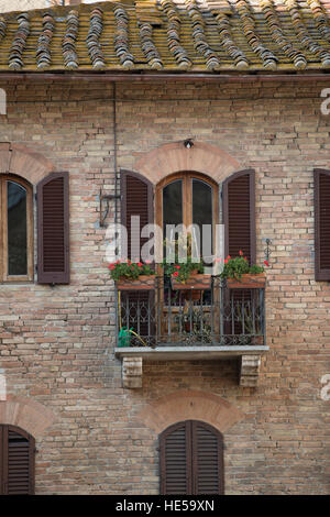 Città medievale di San Gimignano, Toscana, Italia. Casa balcone. Foto Stock