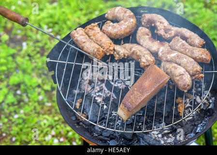 Salsicce e lardo su un grill Foto Stock