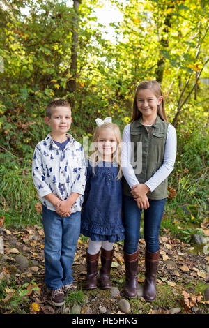 Tre bambini che sono fratelli in una candida foto all'aperto lungo le rive del fiume McKenzie in Oregon. Foto Stock