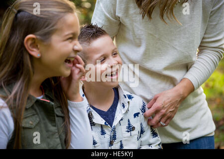 Candide lifestyle ritratto di un giovane ragazzo e sua sorella ridendo e sorridente in un parco naturale. Foto Stock