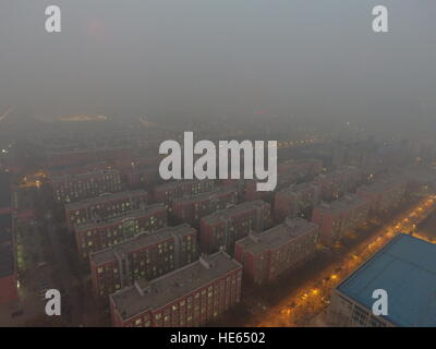 Zhengzh, Zhengzh, Cina. Xviii Dicembre, 2016. Zhengzhou, CINA-Dicembre 18 2016: (solo uso editoriale. Cina OUT) .pesanti protezioni di smog Zhengzhou, capitale della Cina centrale della Provincia di Henan, Dicembre 18th, 2016. Il peggior inquinamento atmosferico finora questo inverno hanno cominciato a muoversi nelle regioni del nord della Cina tra cui Henan, Shandong, Shanxi, Hebei, Tianjin e Pechino il 16 Dic e dovrebbe durare per più di cinque giorni. Il red alert per l'inquinamento atmosferico è stato rilasciato e siano state adottate le misure di emergenza per affrontare lo smog. © SIPA Asia/ZUMA filo/Alamy Live News Foto Stock