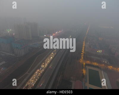 Zhengzh, Zhengzh, Cina. Xviii Dicembre, 2016. Zhengzhou, CINA-Dicembre 18 2016: (solo uso editoriale. Cina OUT) .pesanti protezioni di smog Zhengzhou, capitale della Cina centrale della Provincia di Henan, Dicembre 18th, 2016. Il peggior inquinamento atmosferico finora questo inverno hanno cominciato a muoversi nelle regioni del nord della Cina tra cui Henan, Shandong, Shanxi, Hebei, Tianjin e Pechino il 16 Dic e dovrebbe durare per più di cinque giorni. Il red alert per l'inquinamento atmosferico è stato rilasciato e siano state adottate le misure di emergenza per affrontare lo smog. © SIPA Asia/ZUMA filo/Alamy Live News Foto Stock