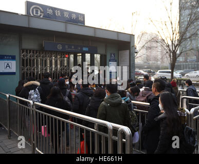 Pechino, Cina. Xix Dec, 2016. Passeggeri in coda per entrare Shuangjing stazione metropolitana sulla linea 10 durante le ore di punta a Pechino Capitale della Cina, Dic 19, 2016. Pechino attivato il suo primo red alert per smog questo inverno sotto la quale il "dispari-pari' restrizione auto è in vigore e altri mezzi di trasporto pubblico è stato disposto, con più bus in funzione più a lungo. © Luo Xiaoguang/Xinhua/Alamy Live News Foto Stock