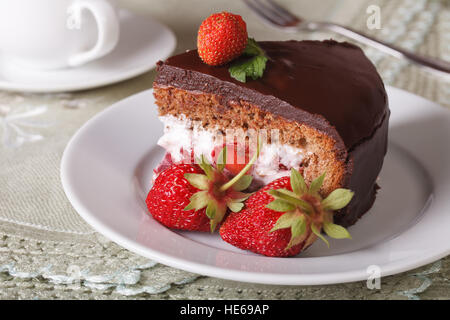 Un pezzo di torta al cioccolato con fragole su una piastra di close-up orizzontale. Foto Stock