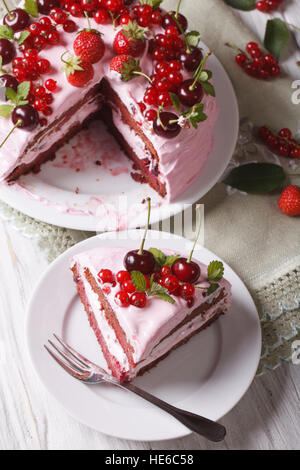 Fette di torta rosa con frutti di bosco freschi sul tavolo di close-up. verticale vista superiore Foto Stock