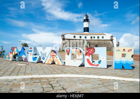 SALVADOR, Brasile - Febbraio 02, 2016: segno colorato si trova di fronte al Colonial Farol da Barra faro. Foto Stock