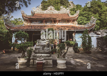 Jolly chubby statua del Buddha nella parte anteriore del piccolo tempio buddista sulle montagne di marmo vicino a Da Nang vietnam Foto Stock