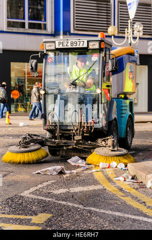 Una piccola strada sweeper raccoglie cucciolata a Belfast. Foto Stock