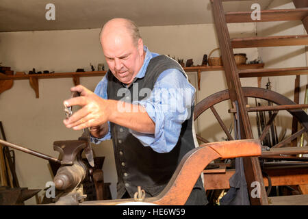 Interprete di lavoro artigiano di Colonial Williamsburg armaiolo shop. Foto Stock