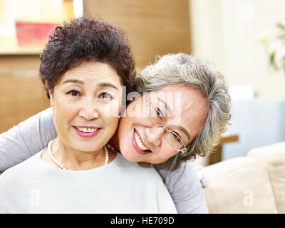 Ritratto di due giocoso senior donne asiatiche guardando la telecamera, felice e sorridente. Foto Stock