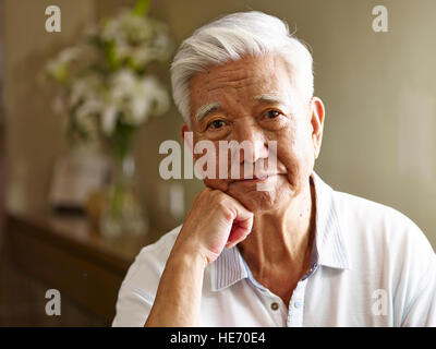 Ritratto di triste senior asian man mano sul mento, vista frontale. Foto Stock