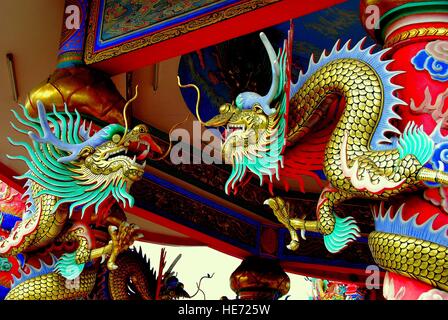 Bang Saen, Tailandia - 7 Gennaio 2010: dragoni dorati rivolti uno verso l'altro da rosso colonne di supporto al Dao De Tian Lin tempio cinese * Foto Stock