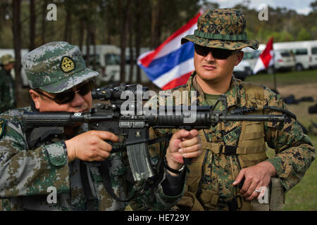 Un popolo cinese della Esercito di Liberazione senior officer con Pechino nella regione militare, sinistra, guarda attraverso il sistema ottico di un m4 carbine mentre si parla con gli Stati Uniti Marine Corps Staff Sgt. Travis W. Hawthorne circa precisione di tiro durante il 2012 Esercito Australiano specialità con bracci riunione (AASAM) in Puckapunyal, Australia, 12 maggio 2012. AASAM è una multinazionale annuale di precisione di tiro consentendo di concorrenza internazionale i membri del servizio per lo scambio di competenze, tattiche, le tecniche e le procedure. Tech. Sgt. Michael R. Holzworth, U.S. Air Force Foto Stock