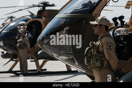 Afghan Air Force MD-530F guerriero Cayuse i piloti di elicottero stand al di fuori dei loro aerei durante il ufficiale 'Roll-Out' cerimonia di MD-530F, 9 aprile 2015, all'Afghanistan Kabul International Airport. Il nuovo aeromobile sarà armato con due FN M3P .50 Cal mitragliatrici. L'elicottero si unirà il Mi-35s e MI-17s per portare aria-terra di incendi supporto al lato delle forze di sicurezza nazionali afgane. ( Staff Sgt. Perry Aston Foto Stock