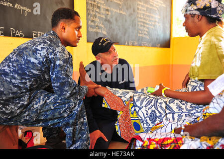 ZOWLA SCUOLA PRIMARIA, Togo (sett. 17, 2012) Ospedale Corpsman 2a classe Edward Lopez esamina il piede di un abitante del Togo come Coast Guard campo ausiliario Service Officer James Kushner si traduce in un medico azione civica Sanità del programma FAIR. Il personale medico hanno avviato da Alta Velocità nave Swift (HSV 2) come parte di un Africa Partnership Stazione (AP) visita. PS è un internazionale di cooperazione per la sicurezza iniziativa, facilitato dal comandante, U.S. Forze Navali, Europa-Africa volto a rafforzare marittimo globale attraverso partenariati di formazione e di attività di collaborazione al fine di impro Foto Stock