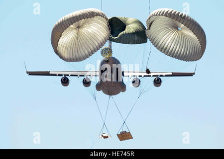 Membri della cinquantottesima Airlift Squadron unilaterale di rilascio di airdrop carichi di formazione da una C-17 Globemaster III durante un airdrop missione di formazione in corrispondenza della prima zona di caduta, 11 aprile 2014, nei pressi di Hollis, Okla. La 97th operazioni aeree volo prepara airdrop cargo pallet e li carica su il C-17s. La loro missione fornisce C-17 personale di volo con scenari realistici che consistono di on e off il caricamento di carico generale e veicoli come pure la consegna dell'antenna di materiali per la formazione di airdrop. Senior Airman Jesse Lopez) Foto Stock