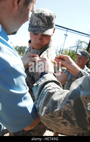 Airman 1. Classe Matteo Garner ha la sua scheda Ranger riposte su da suo padre Don Garner e mentor, Staff Sgt. Seth Hunter, 29 aprile 2011. Dopo aver completato la intensa 61-giorno U.S. Army Ranger scuola a piedi. Benning, Ga. Airman Garner era il solo Airman fare attraverso il corso per questa classe ed è uno dei meno di 300 per renderlo poiché la scuola ha aperto negli anni cinquanta. Airman Garner è assegnato alla base 823rd squadrone di difesa. Airman 1. Classe Brigitte N. Brantley-Sisk) Foto Stock