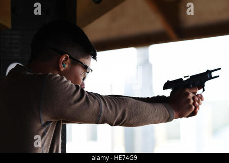 Senior Airman Kevin Sekishiro, 423rd delle forze di sicurezza Squadron patrolman, incendi di un round da un M9 pistola durante una polizia nazionale settimana concorso di tiro a RAF Molesworth, Inghilterra, 13 maggio 2015. Settimana di polizia è stato istituito in onore di funzionari di polizia che hanno dato la loro vita nella linea del dazio. Il personale Sgt. Jarad A. Denton Foto Stock