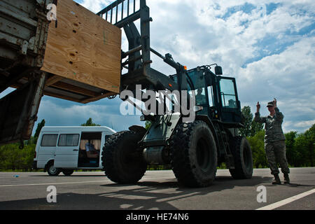 Il personale Sgt. Russell Larsen opera un bruco 10K All-Terrain carrello per caricare una perfusione cardiaca macchina su un autocarro in attesa mentre Senior Airman Lydia Newman fornisce linee guida presso il Centro di Transito a Manas, Kirghizistan, 16 giugno 2012. La 376 Expeditionary disponibilità logistica Squadron assistito nel trasporto di apparecchiature destinate ad essere consegnate a Bishkek per bambini Centro cardiaco. Larsen è 376 ELRS non commissionato ufficiale responsabile del carico in entrata distribuita di Travis Air Force Base in California, ed è un nativo di Los Angeles e Newman è un 376 ELRS cargo anche processore dep Foto Stock