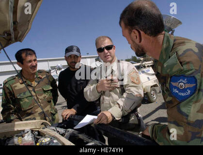 Stati Uniti Air Force mentor Master Sgt. Michael Stoller (secondo da destra) funziona con i membri dell'esercito nazionale afghano air corps, il 25 luglio a Kabul International Airport (KIA) Afghanistan. Stoller è un veicolo artigiano di manutenzione ed è distribuito da Eielson Air Force Base in Alaska. Stoller è assegnato al combinato per la sicurezza nella fase di transizione (Command-Afghanistan CSTC-A) che ha sede a Camp Eggers, Kabul, Afghanistan. CSTC-un partner con il governo della Repubblica islamica dell'Afghanistan e la comunità internazionale, per pianificare, programmare e implementare strutturali, organizzativo, in Foto Stock