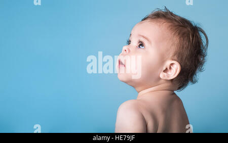 Carino Bambina cercando fino contro la vivace sfondo blu Foto Stock