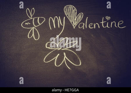 Disegno a mano con un gessetto sulla lavagna, cute kawaii doodle bee, cuore e parole essere mio Valentine, modello per biglietto di auguri Foto Stock