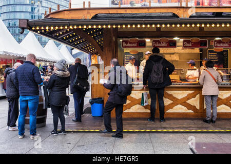 Berlino, Mitte, Potsdamerplatz. Persone che acquistano hotdog, bratwurst, frikadelle a Natale Tedesco di stallo del mercato Foto Stock