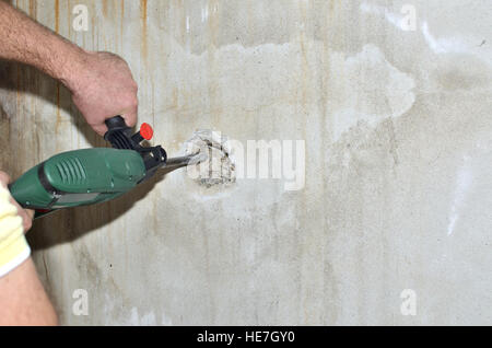 Cesello elettrico macchina rendendo foro in un muro di cemento Foto Stock