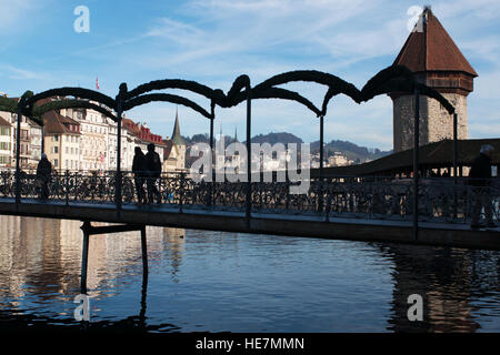 La Svizzera, Europa: la gente che camminava sul Rathaussteg, il ponte Ponte sopra il fiume Reuss, con lo skyline di Lucerna e la Torre dell'acqua Foto Stock